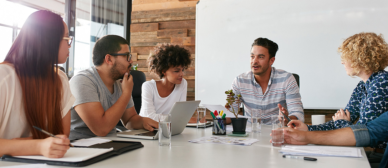 Shot of a group of young business professionals having a meeting in boardroom. Office workers discussing new business plan together in a conference room.